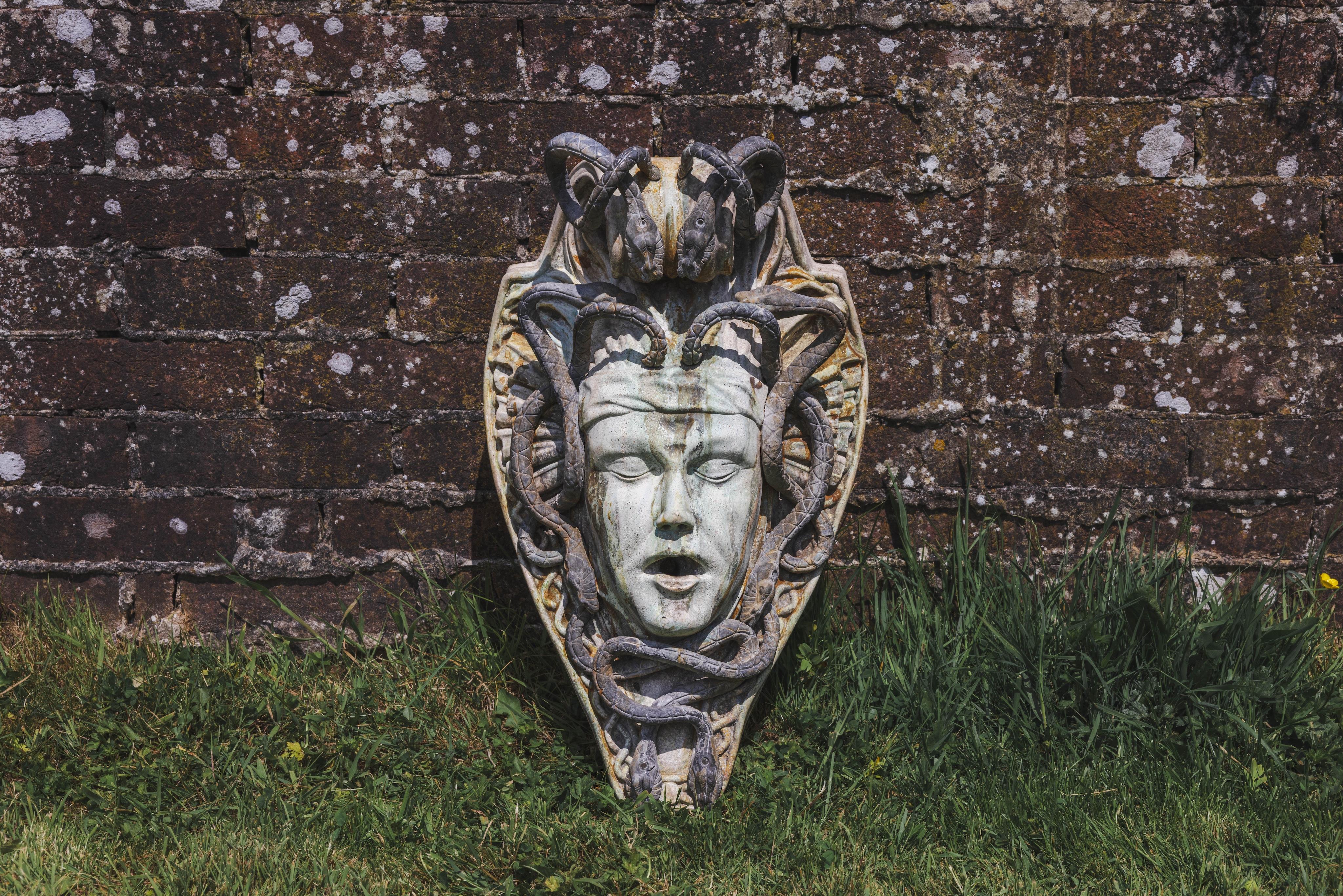 A reconstituted marble and lead Medusa wall fountain head, height 54cm